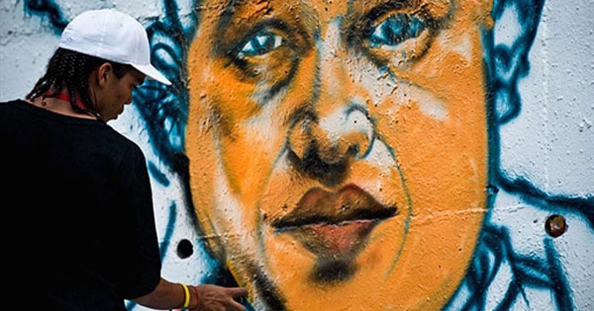 Венесуела, Каракас. Вуличний художник Вільдемар Льєндо малює графітті із зображенням президента Венесуели Уго Чавеса на стіні на одній з головних вулиць Каракаса. / © AFP