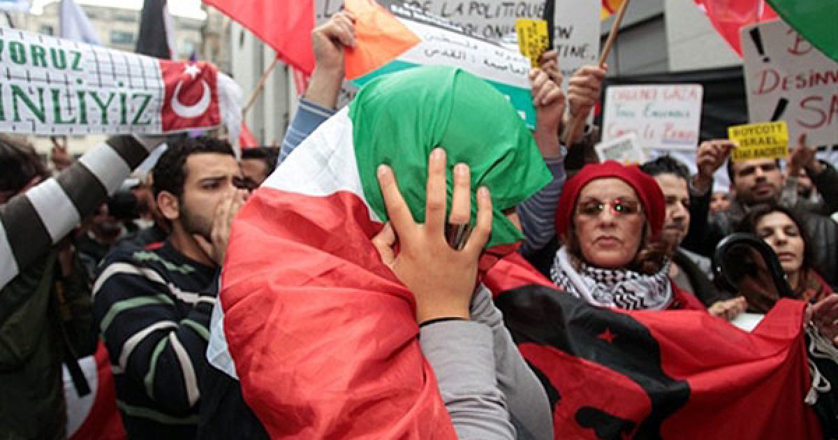 Бельгія, Брюссель. Демонстрант, загорнутий у палестинський прапор, під час антиізраїльської акції протесту. / © AFP