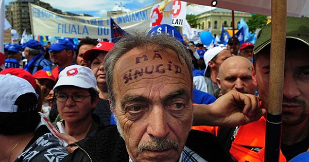 Румунія, Бухарест. Напис на лобі у румунського мітингувальника: "Я вб&rsquo;ю себе". Перед штаб-квартирою уряду в Бухаресті пройшли масові антиурядові акції протесту. Тисячі мітингувальників висловили протест проти запланованого 25-відсоткового скорочення їхньої заробітної плати. МВФ, ЄС і Світовий банк минулого року уклали "кризову" угоду з Румунією на 20 млрд євро в обмін на скорочення державних видатків у країні. Середній розмір пенсії у Румунії становить близько 190 євро, середня зарплата близько 350 євро. / © AFP
