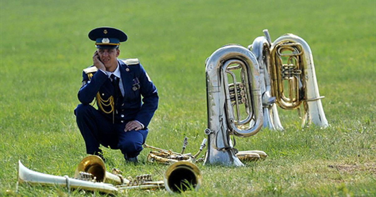 Член Національного військового оркестру України відпочиває під час репетиції параду на честь 65-ої річниці закінчення Другої світової війни у Києві. В урочистому параду на честь Дня перемоги візьмуть участь українські, російські та білоруські війська. / © AFP