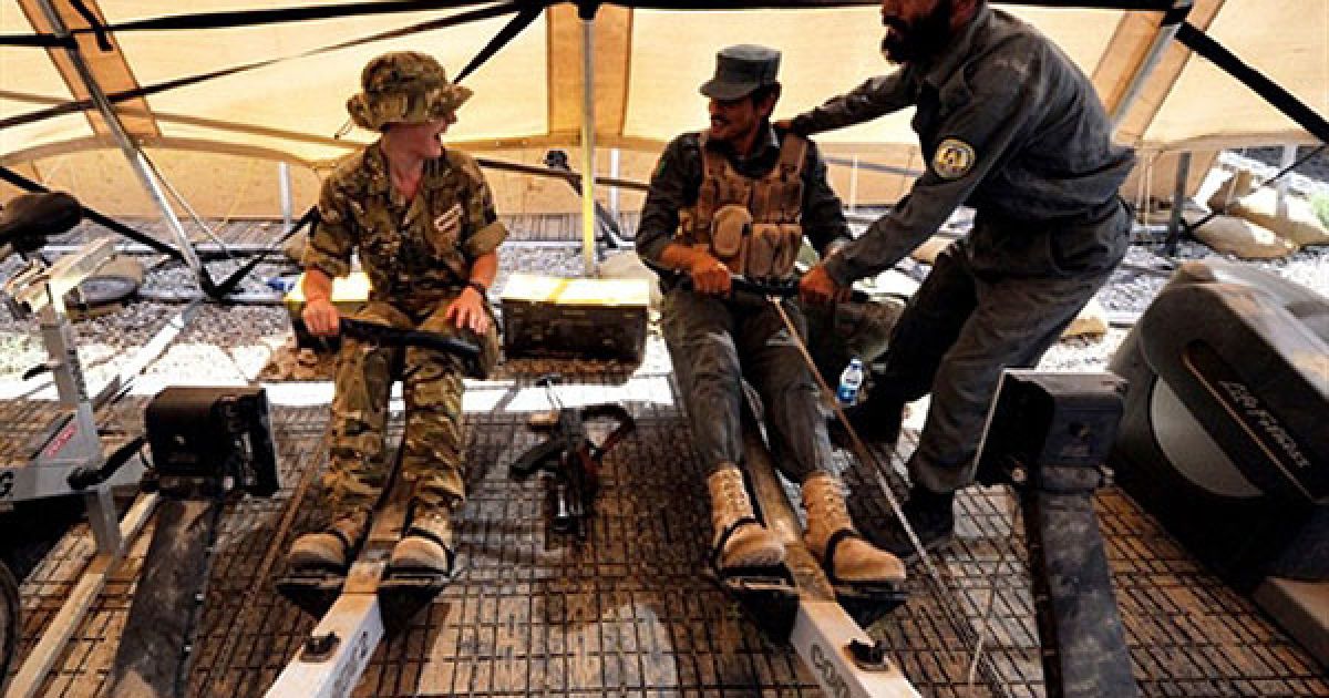 Співробітник управління з питань освіти капітан Бредлі Абі (ліворуч) тренується разом із афганськими поліцейськими у спортзалі на патрульній базі гуркхів у таборі Нахр-Е-Сарай, провінція Гільменд. / © AFP