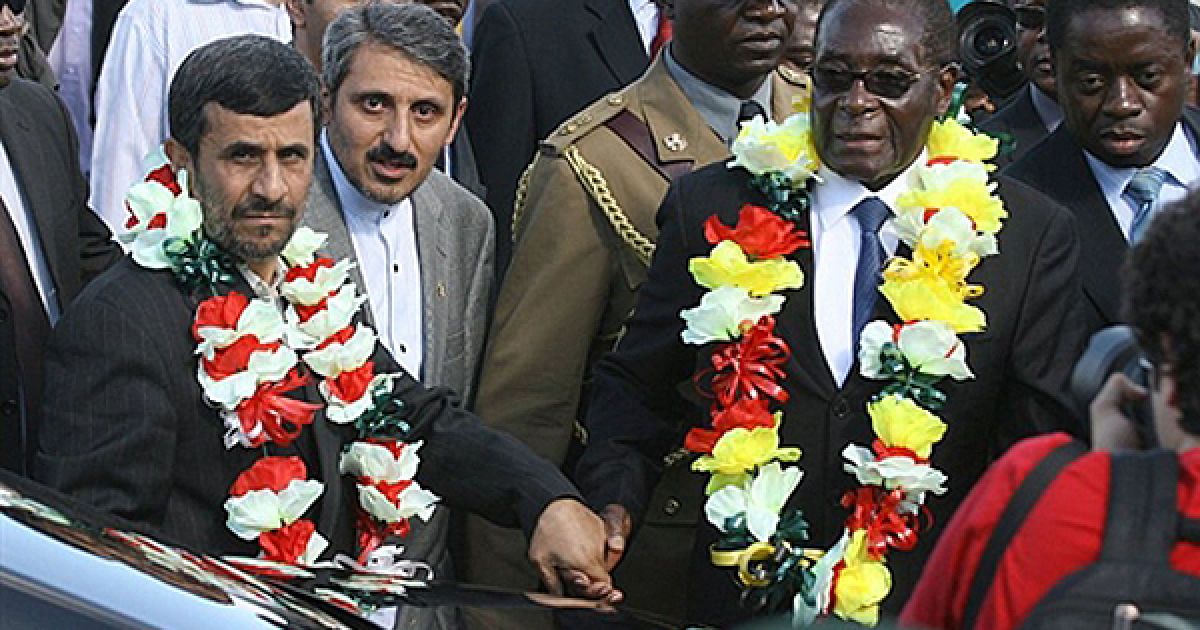 Президент Зімбабве Роберт Мугабе зустрічає президента Іран Махмуда Ахмадінеджада у аеропорті Хараре. Ахмадінеджад прибув до Зімбабве на запрошення Мугабе для участі в інвестиційному форумі. Опозиція Зімбабве жорстоко розкритикувала візит президента Ірану, оскільки це може зашкодити міжнародному авторитету країни. / © AFP