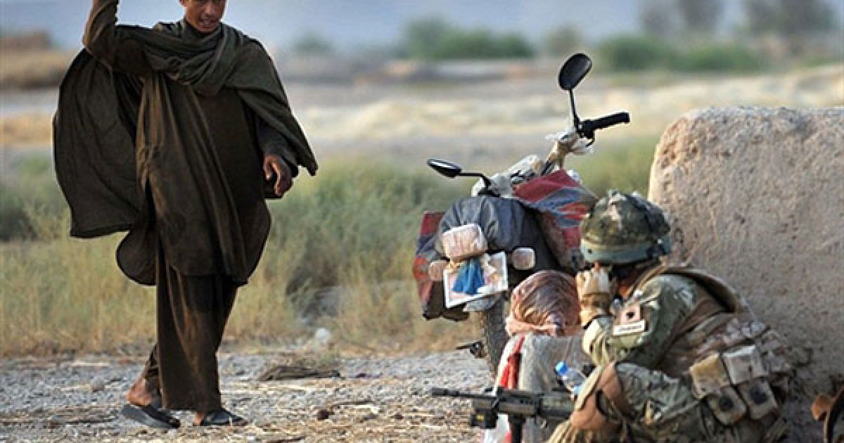 Афганець кидає цибулину солдату, який знаходиться на патрулюванні / © AFP