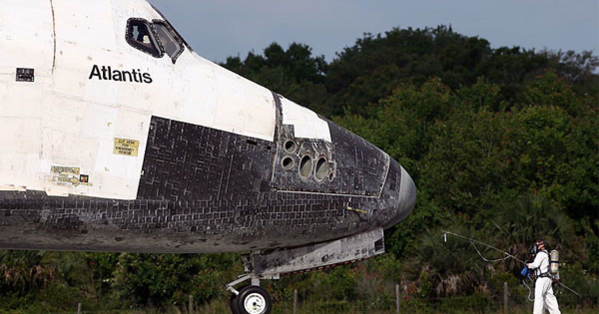 США, мис Канаверал. Поверхню шаттла "Атлантіс" перевіряють на наяявність шкідливих речовин. Космічний корабель "Атлантіс" приземлився в аеропорту імені Кеннеді Космічного центру НАСА на мисі Канаверал, штат Флорида. Шаттл "Атлантіс" здійснив свій останній політ і завершив 25-річну "кар'єру".