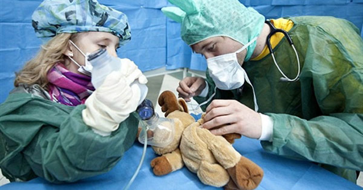 Німеччина, Берлін. Дитина та студент-медик проводять "операцію" на ляльці у так званій "Лікарні Teddy Bear". "Лікарню Teddy Bear" організували студенти для дітей дошкільного віку, з метою зменшити їхній страх перед лікарями та лікарнями. / © AFP