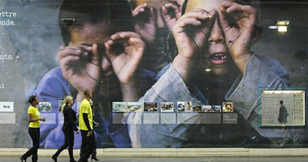 Франція, Париж. Перехожі проходять повз гігантську роботу іранського фотографа Реза Дегаті, виставлену на платформі паризького метро на станції "Люксембург". У паризькому метро до 12 вересня проходитиме виставка "Паралельні шляхи".