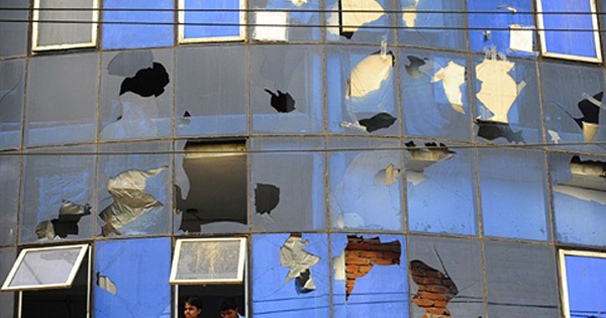 Чоловіки дивляться з вікна однієї з текстильних фабрик Дакки. Сьогодні більшість фабрик, які виробляють одяг для західних брендів, відкрилися під пильною охороною місцевої поліції після масових заворушень. Більшість співробітників цих заводів, які оголосили 19 червня страйк, сьогодні вийшли на роботу. / © AFP