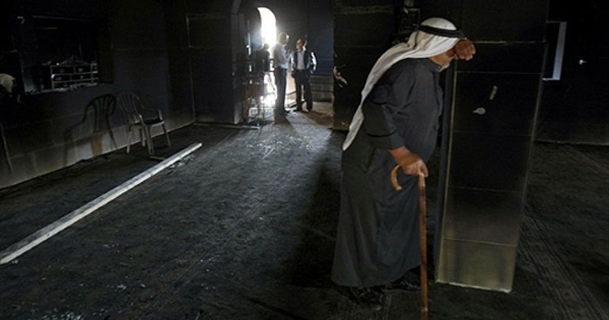 Чоловік плаче у стінах мечеті, в якій сталася пожежа, у Наблусі. Палестинці звинувачують у пожежі ізраїльських поселенців, а ізраїльська сторона струджує, що причиною пожежі могло стати коротке замикання. / © AFP