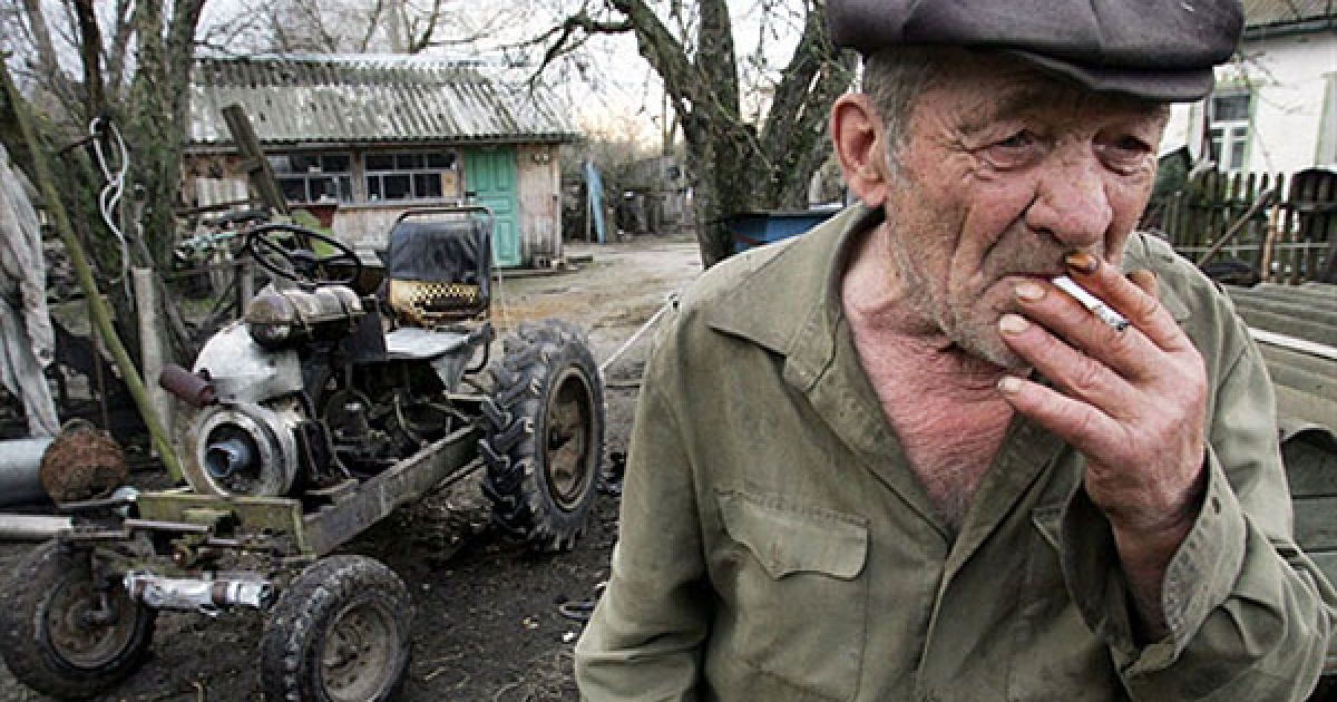 Україна, село Ільїнці, 30-км зона. Мешканець Ільїнців Микола Коваленко поруч з трактором, який він зібрав власноруч. / © AFP