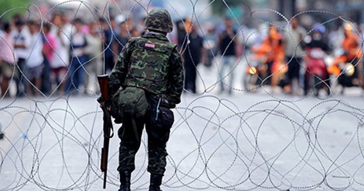 Таїланд, Бангкок. Тайський військовий стоїть перед бар&rsquo;єром з колючого дроту. У Бангкоку відбулись збройні зіткнення між військовими та демонстрантами з антиурядового руху "Червоних сорочок". Тайські війська відкрили вогонь по мітингувальникам, одна людина була убита, щонайменше 21 отримали поранення. / © AFP