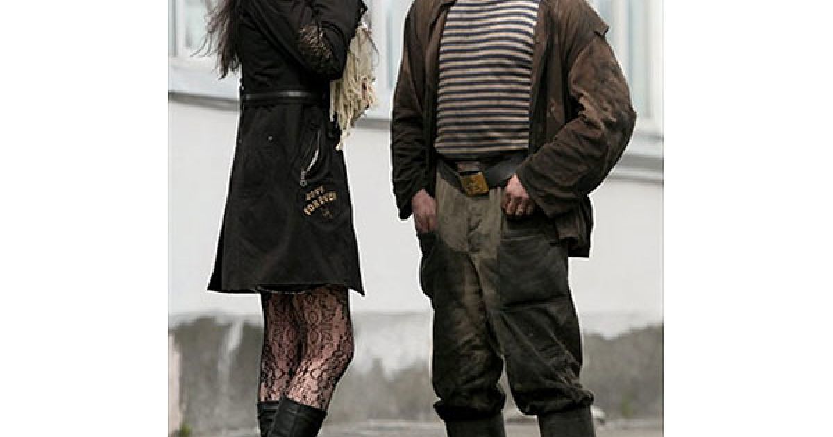 Росія, Междуреченськ. Рятувальник і дівчина стоять поруч із шахтою "Распадська", на якій сталося кілька вибухів метану, в результаті чого загинула 31 людина. Рятувальники роблять усе моживе для того, щоб знайти 59 гірників і рятувальників, які потрапили у пастку всередині шахти. / © AFP