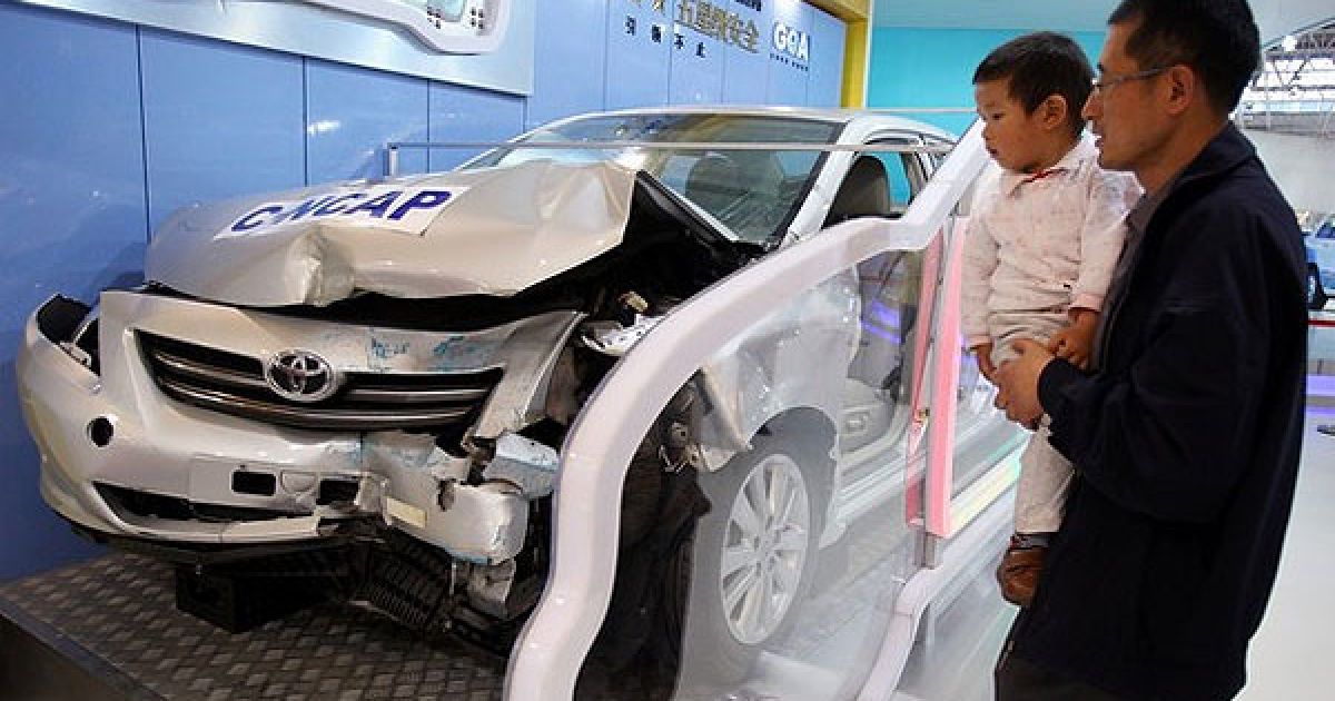 Відвідувач з дитиною роздивляються Toyota Carolla після краш-тесту. / © Getty Images/Fotobank