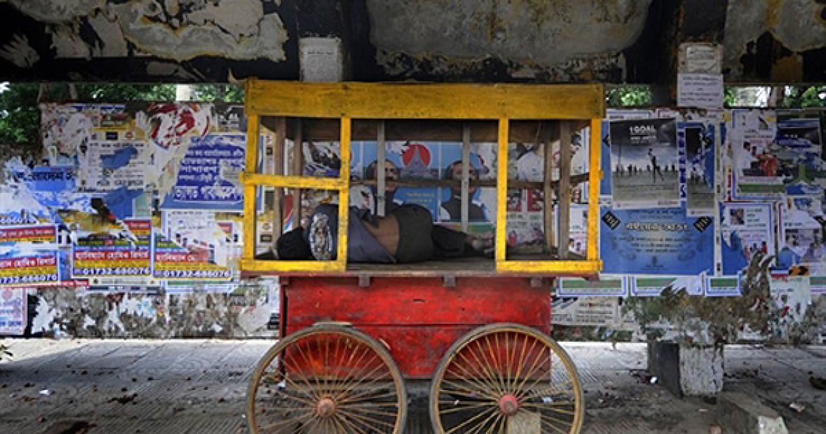 Дакка. Вуличний продавець спить у своєму кіоску. Більшість людей у Бангладеш живе менше, ніж на 1 долар на день. / © AFP