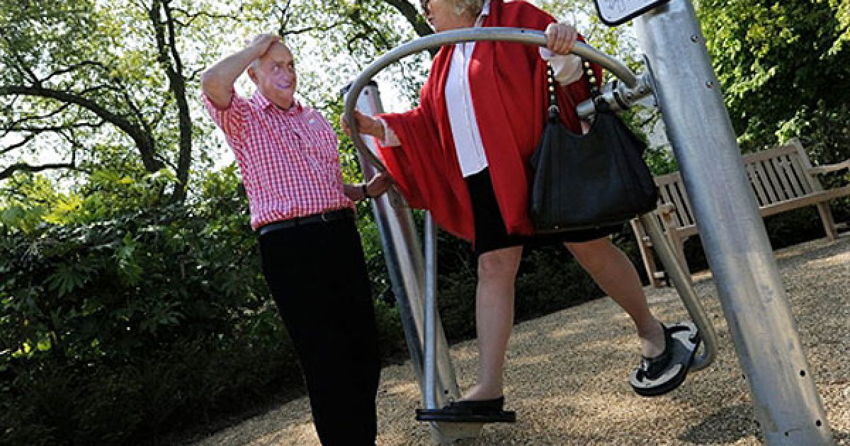 Великобританія, Лондон. Британський пенсіонер Уїнстон Флетчер розмовляє зі своєю подругою Маргарет Манн, яка виконує вправи на тренажері під час відкриття першого майданчика для пенсіонерів у Гайд-парку. Об&rsquo;єкт обладнано фітнес-тренажерами, які дають змогу підтримувати і розвивати міцність і гнучкість, можуть допомогти людям похилого віку вести активний і здоровий спосіб життя. Подібні майданчики для людей похилого віку дуже популярні в Китаї. / © AFP