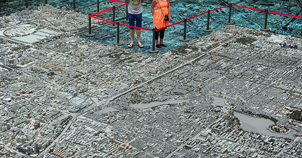 Китай, Пекін. Відвідувачі роздивляються мініатюрну модель китайської столиці, представлену на виставці міського планування у Пекіні. За офіційними даними, у травні було зафіксовано зниження зростання цін на нерухомість.