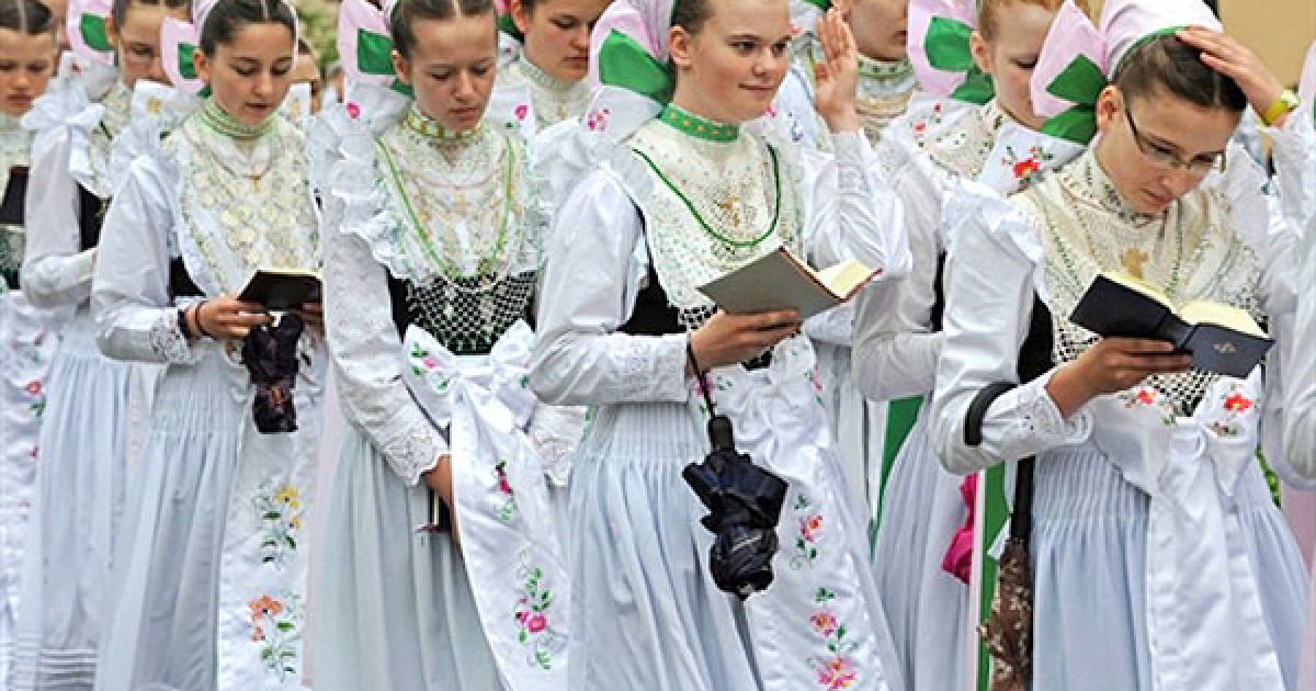 Німеччина. Подружки нареченої у сербських національних костюмах, "дружки", під час традиційної процесії у місті Кроствітц, Східна Німеччина. Католики відзначають свято Тіла Христового. / © AFP