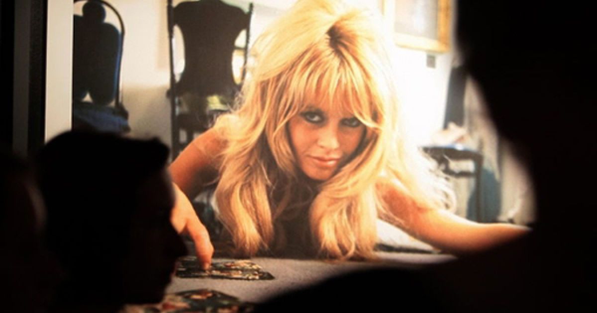 Відвідувачі фотографують плакат із зображенням французької акторки та моделі Бріджит Бардо під час відкриття виставки її фотографій у Сен-Тропе. / © AFP