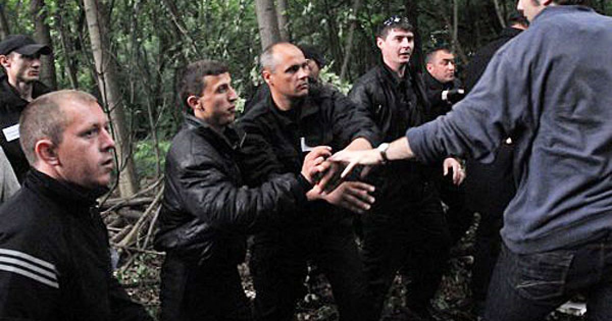 Співробітники муніципальної охорони та противник вирубки лісу в міському парку їм. Горького під час сутички на місці будівництва дорогі 31 травня 2010 р. / © УНІАН