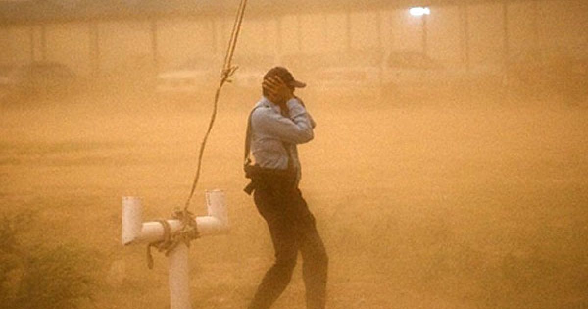 Пакистан, Ісламабад. Пакистанський поліцейський ховається від пилової бурі на КПП у Ісламабаді. На місто обрушилась піщана буря із невеликим дощем. Очікується, що потужні бурі наближаються до Ісламабаду, Пенджабу, Лахору, Гужранвали. / © AFP