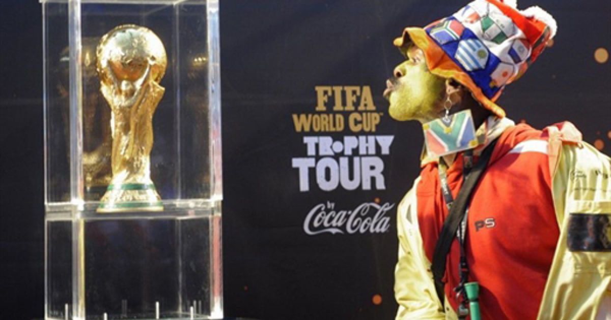 Південноафриканський вболівальник фотографується із Кубком Світу у аеропорті Кейптауну перед початком туру Кубку. / © AFP