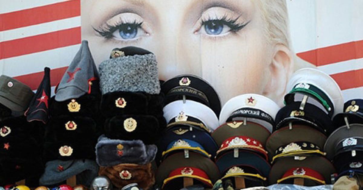 Німеччина, Берлін. Сувеніри з НДР (Німецької Демократичної Республіки) і Радянського Союзу виставлені перед вітриною з рекламою, на які зображено американську співачку Крістіну Агілеру. / © AFP