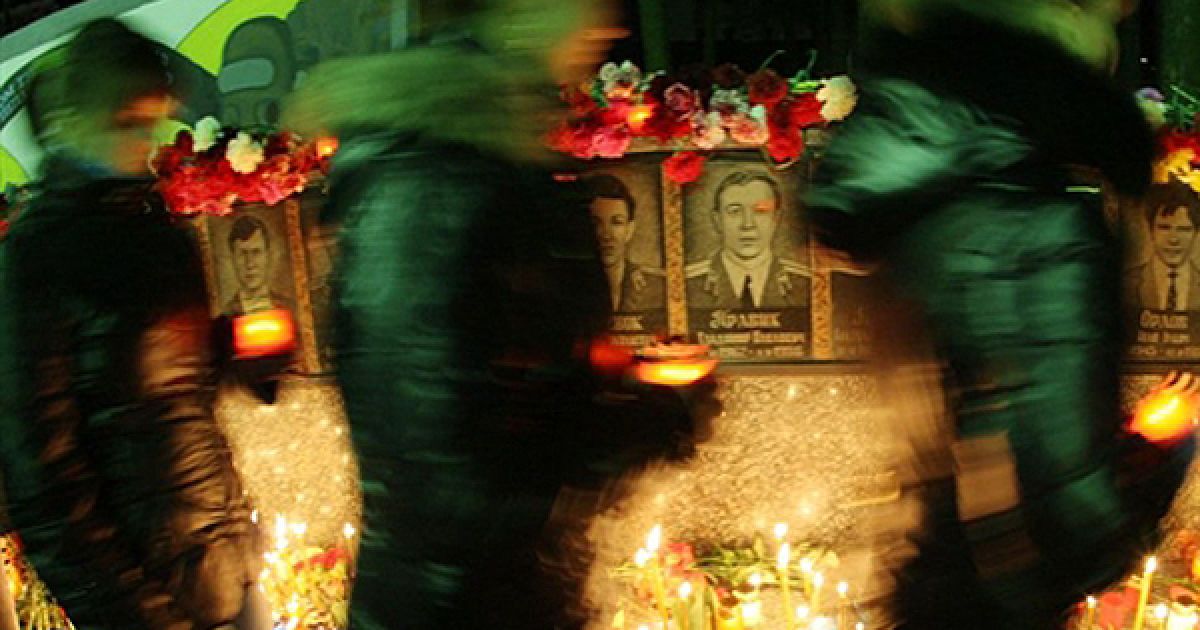 Люди ставлять свічки до пам’ятника ліквідаторам аварії на ЧАЕС у Славутичі, Київська область, у 24-ту річницю Чорнобильської катастрофи. / © AFP
