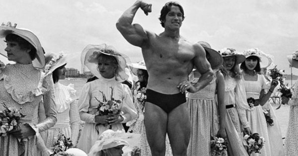 1977 рік. Арнольд Шварценеггер позує на пляжі з молодими актрисами. / © Getty Images/Fotobank