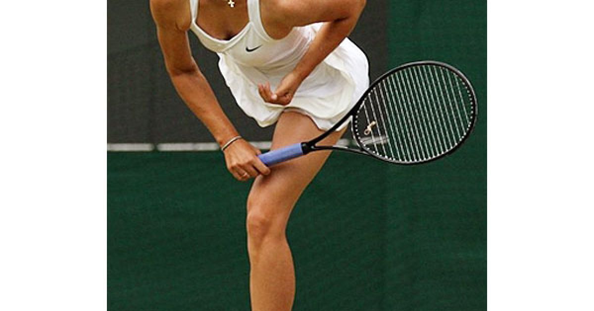 Великобританія, Вімблдон. Російська тенісистка Марія Шарапова відбиває подачу румунської спортсменки Йоани Ралуки Олару під час гри у рамках тенісного турніру "Вїмблдон". / © AFP