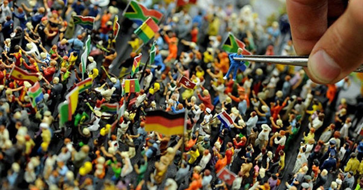 Німеччина, Гамбург. Співробітник "Miniatur Wunderland" ("Мініатюрний дивосвіт") ставить на місце фігурку уболівальника за допомогою пінцета. Під час Чемпіонату світу з футболу у "Мініатюрному дивосвіті" демонструватимуть експозицію з моделей футбольних фанатів, матчів тощо. / © AFP