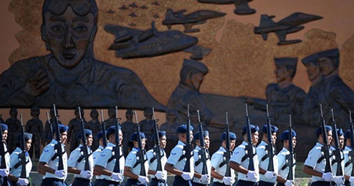 Філіппіни, Маніла. Філіппінські охоронці проходять маршем повз розпис на стіні. У Манілі пройшов урочистий Парад подяки на честь збройних сил Філіппін. Новообраний президент Філіппін Беніньо Акіно оголосив про проведення реформи у збройних силах країни. / © AFP