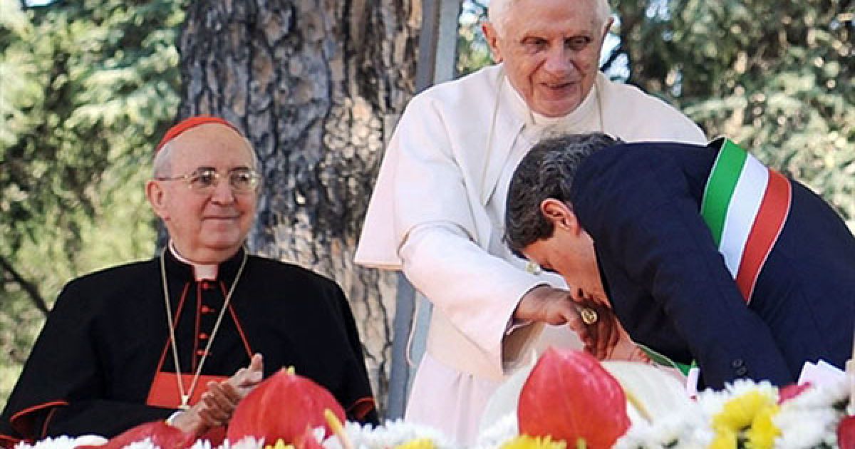 Італія, Рим. Мер Риму Джанні Алеманно цілує руку Папі Римському Бенедикту XVI під час його візиту до центру Дон Оріоні для отримання благословення від Мадонни Дон Оріоні. Статуя, що, як вважають, охороняє Рим, була серйозно пошкоджена під час шторму, а тепер повернулася на колишнє місце після реставрації. / © AFP