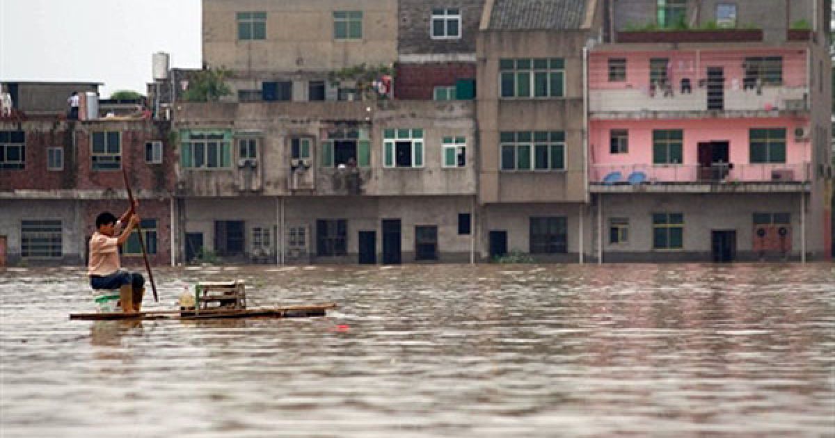 Китай, Фучжоу. Китаєць пливе на саморобному плоту затопленими вулицями міста Фучжоу у провінції Цзянсі східного Китаю. Синоптики попереджають про нові зливи, які насуваються на країну. Південна частина Китаю вже постраждала від повеней і попередніх злив, які забрали життя більше 200 людей. / © AFP