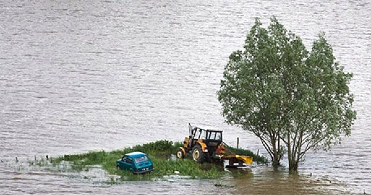 Польща, Свиняри. Покинуті автомобіль і трактор, оточені водою, у селі Свиняри, розташованому в центральній Польщі на річці Вісла. Кількість загиблих від повеней у Польщі зросла до 15 людей. Через проливні дощі підвищився рівень води у більшості річок. / © AFP