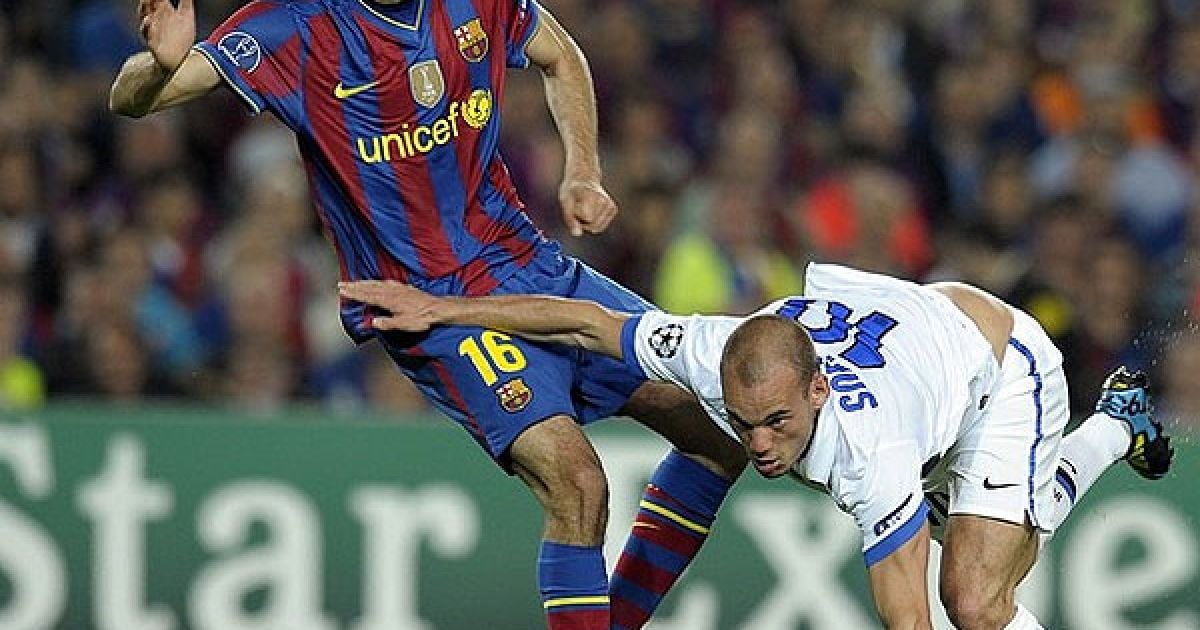Півзахисник "Інтера" Веслі Снейдер проривається до м’яча повз півзахисника "Барселони" Серхіо Бускетса. / © AFP