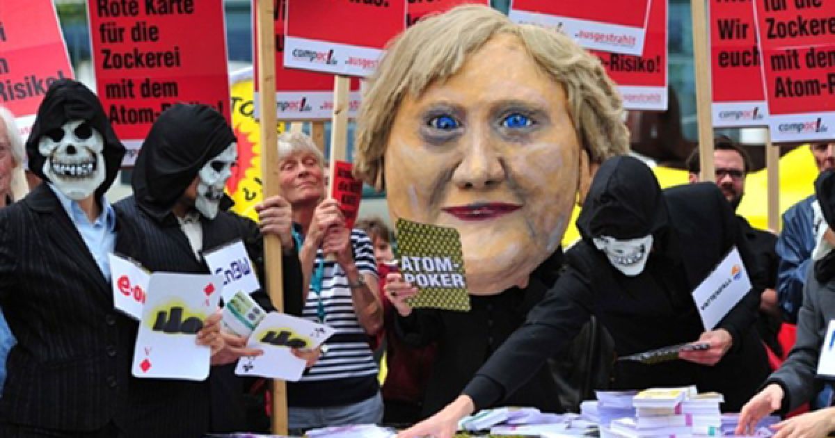 Активісти природоохоронних організацій грають у покер із опудалом Ангели Меркель під час мітингу проти ядерної політики біля Державної канцелярії у Берліні. Ангела Меркель мала зустрітися із головами найбільших німецьких енергетичних компаній для обговорення строку експлуатації АЕС. / © AFP