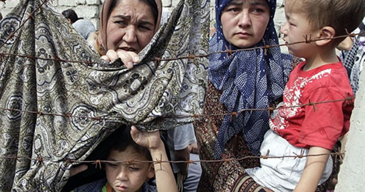 Киргизстан, Сураташ. Етнічні узбецькі біженці чекають на киргизько-узбецькому кордоні поруч із містом Сураташ. Узбекистан закрив свій кордон для десятків тисяч біженців, які рятуються від міжетнічних зіткнень між конфліктуючими угрупованнями у Киргизстані. Урядові війська Киргизії були звинувачені у сприянні вбивствам етнічних узбеків у країні. / © AFP