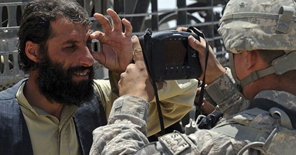 Афганістан, Кандагар. Американський солдат ударної бригадної тактичної групи виконує сканування сітківки ока афганського чоловіка під час патрулювання в одному з районів Кандагара. НАТО і США переводять до країни тисячі нових військовослужбовців, очікується, що іноземний контингент у Афганістані в серпні 2010 року становитиме 150 тисяч осіб. / © AFP