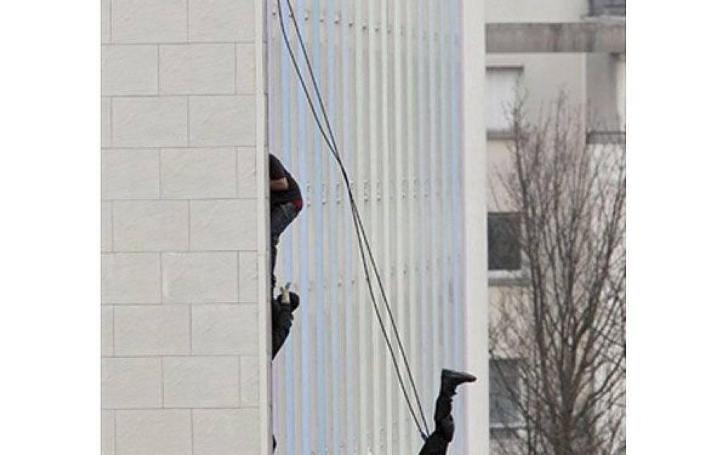 Франція, Роні-су-Буа. Французькі поліцейські намагаються зупинити чоловіка, який погрожує здійснити самогубство. 29-річний чоловик вдерся до чужої квартири із застосуванням вогнепальної зброї, згвалтував мешканку будинку, а потім протягом трьох годин провисів на висоті п&#039;ятого поверху, доки його звідти зняла поліція. / © AFP