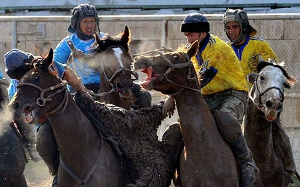 Киргизстан, Бішкек. Киргизькі чоловіки грають у традиційний центральноазіатський вид "спорту" &mdash; бузкаші, або кок-бору, у Бішкеку. Гравці на конях борються за очки, намагаючись закинути опудало цапа у колодязь. / © AFP