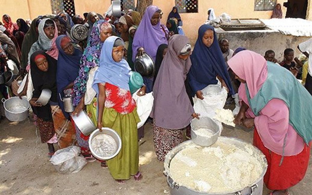 Сомалі, Даркенлі. Сомалійські жінки та діти чекають у черзі, щоб отримати їжу від місцевої організації Всесвітньої продовольчої програми у центрі годування на південь від Могадішо. / © AFP