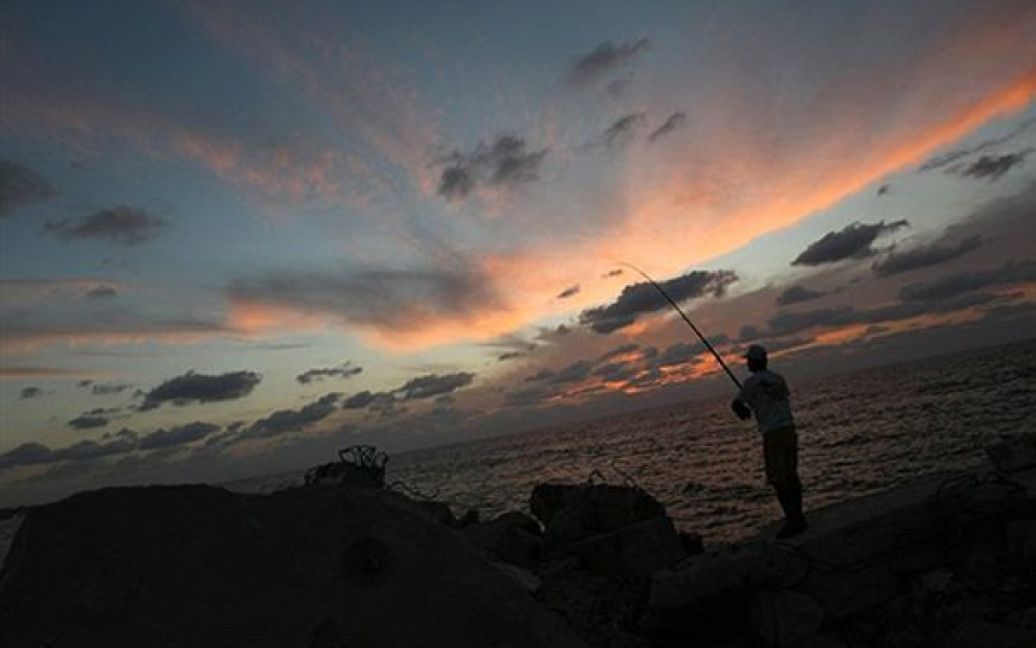 Чоловік ловить рибу у порту Сектора Гази. / © AFP