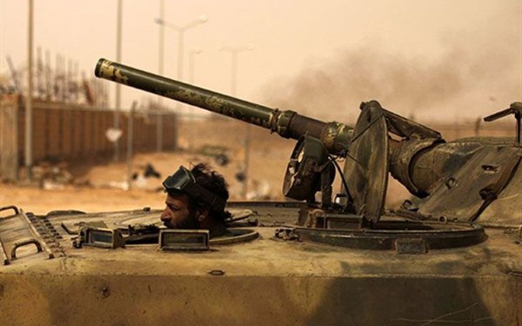 Лівійська Арабська Джамахірія, Аждабія. Лівійський повстанець веде танк на лінію бойових дій у місті Аждабія, де урядові війська обстріляли позиції повстанців. / © AFP