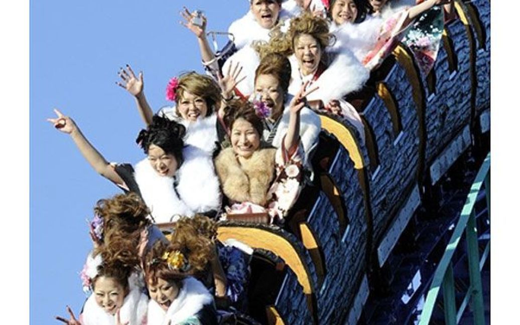 Японія, Токіо. Молоді японські жінки у кімоно катаються на американських гірках після участі у церемонії на День повноліття, під час якої святкують їх перехід до дорослого життя. У церемонії взяли участь більше тисячі японців, яким виповнилось 20 років, і їх офіційно визнали дорослими. / © AFP