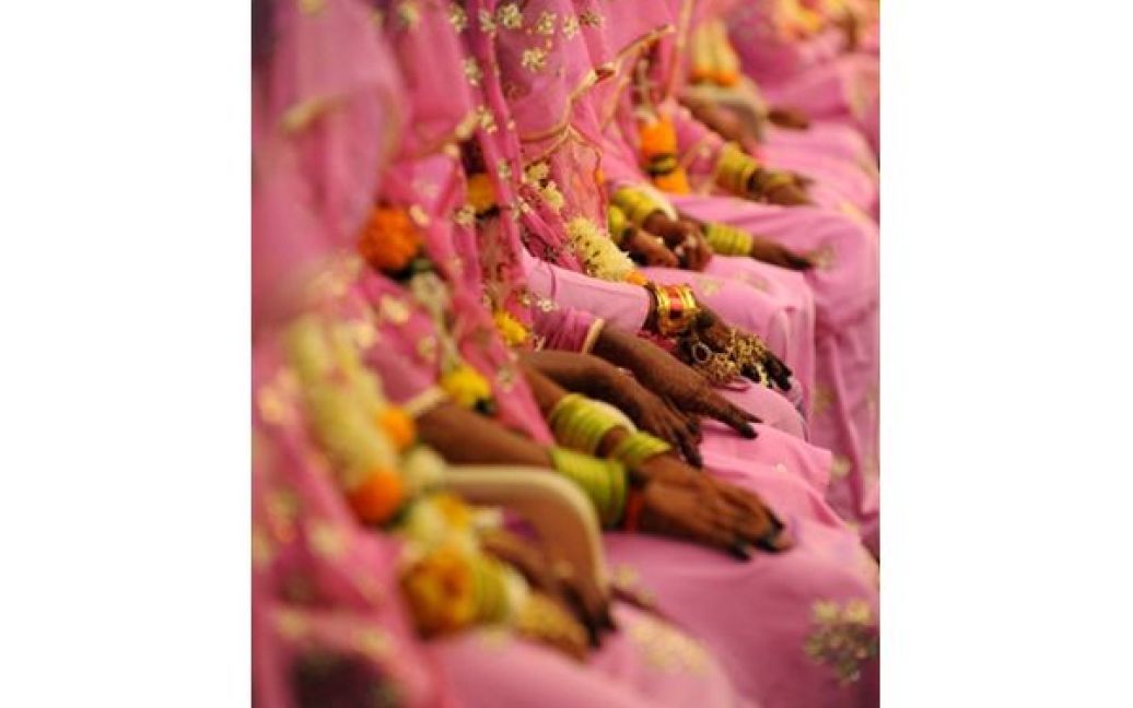 Мусульманські наречені чекають на початок церемонії масового весілля у Ахмедабаді. Сьогодні у мерії Ахмедабаду взяли шлюб одразу 65 молодих пар. / © AFP