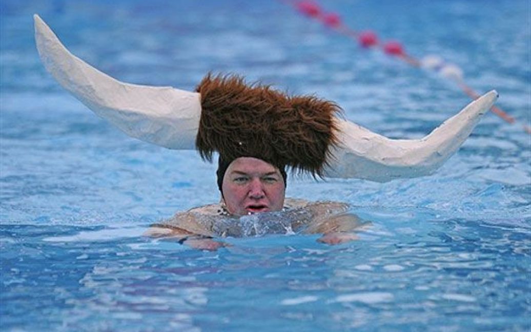 Великобританія, Лондон. Чоловік у дивній шапці з рогами бере участь у запливі на Чемпіонаті з плавання у холодній воді, який пройшов у відкритому басейні "Тутінг Бек" у Південному Лондоні. / © AFP