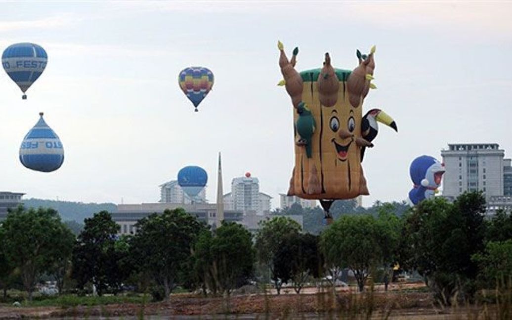 Малайзія, Путраджайя. Гігантська повітряна куля "Стовбур", пілотована американським повітроплавецем Гері Муром, летить у небі над столицею Малайзії. Близько 28 повітряних кулях з понад 14 країн взяли участь у 3-му Міжнародному святі повітряних куль. / © AFP