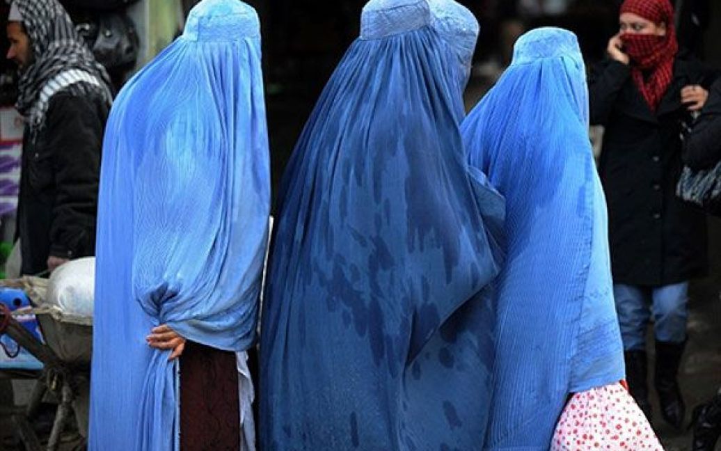 Афганістан, Кабул. Афганські жінки, одягнені у традиційний одяг, проходять повз магазини на ринку в Кабулі. / © AFP
