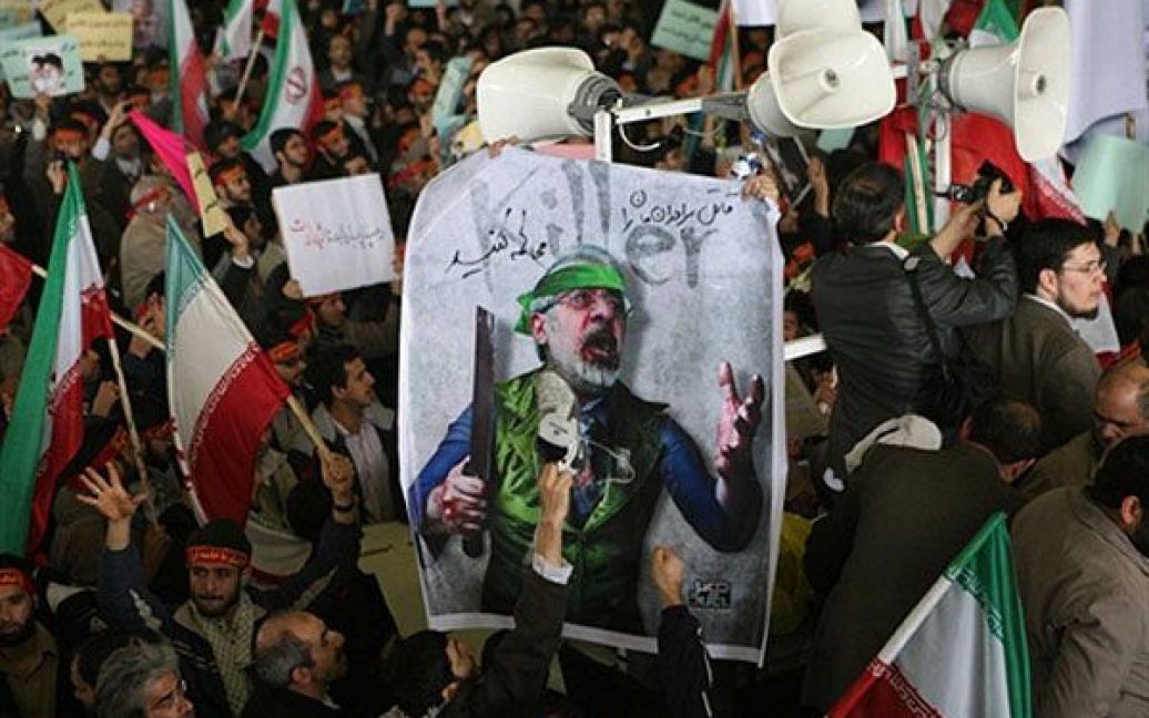 Іран, Тегеран. Чоловік б&rsquo;є черевиком у плакат із зображенням реформістського лідера опозиції Міра Хосейна Мусаві під час похорону студент, який був убитий два дні тому під час мітингу опозиції у Тегерані. / © AFP