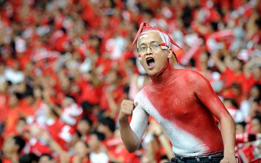 Індонезія, Джакарта. Індонезійський уболівальник підтримує свою команду під час другої фінальної гри футбольного Кубку Suzuki AFF у Джакарті. Кубок виграла збірна Малайзії. / © AFP