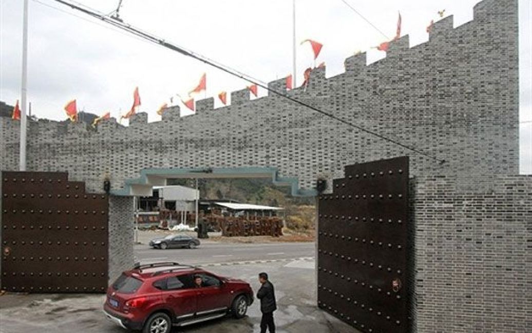 Китай, Тайчжоу. Автомобіль заїжджає до воріт у "Великій стіні", яку побудували у селищі Тайчжоу, провінція Чжецзян. Жителі села прислухались до стародавніх імператорів та побудували "Велику стіну" навколо селища, щоб захистити заможну спільноту від злодіїв. / © AFP
